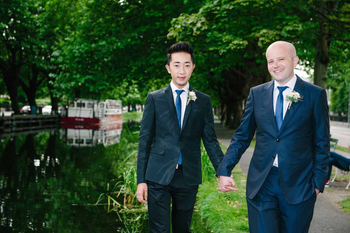 Two grooms photographed standing on the locks crossing the Grand Canal in Dublin during their LGBT Gay Wedding. 