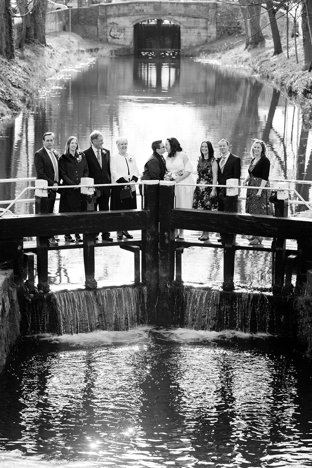 A couple photographed with their families standing on the lock crossing the Grand Canal during their LGBTQ Wedding