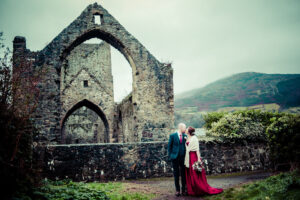 The bride and groom pose in front of the ruins of Carlingford Abbey in a micro wedding photo