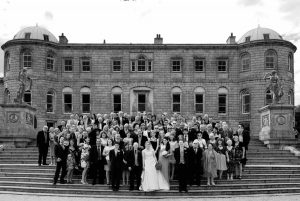 Wedding guests pose for a Powerscourt Wedding Photograph on the steps in the grounds of the estate gardens